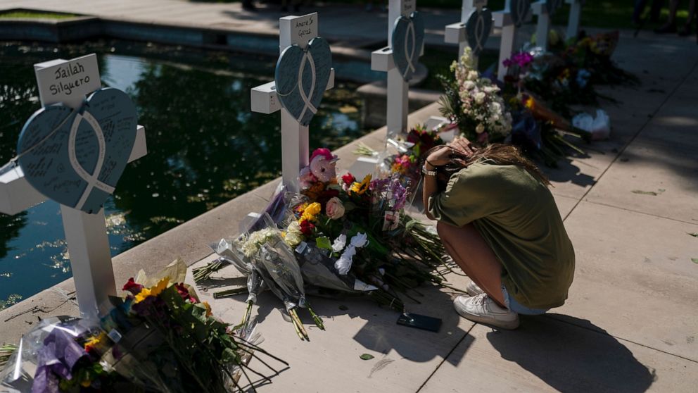 Elena Mendoza, 18, grieves in front of a cross honoring her cousin, Amerie Jo Garza, one of the victims killed in this week's elementary school shooting in Uvalde, Texas, Thursday, May 26, 2022. (AP Photo/Jae C. Hong)