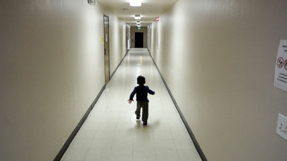 FILE - In this Dec. 11, 2018 file photo, an asylum-seeking boy from Central America runs down a hallway after arriving from an immigration detention center to a shelter in San Diego. Lawyers for eight immigrant families separated under Trump administ