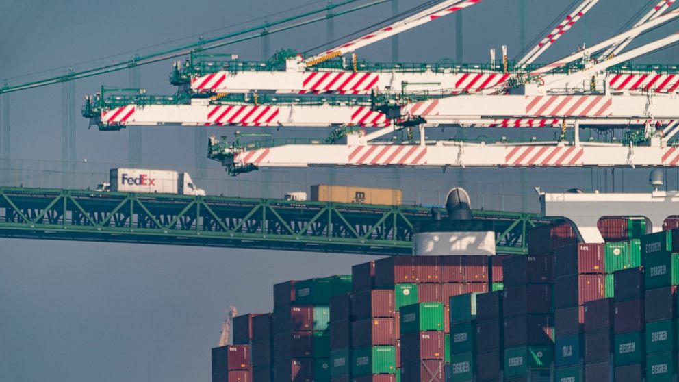 FILE - Transportation trucks cross the Vincent Thomas Bridge over the main channel as shipping containers are seen stacked on the Evergreen terminal at the Port of Los Angeles in San Pedro, Calif., Nov. 30, 2021. A contract between shipping companies
