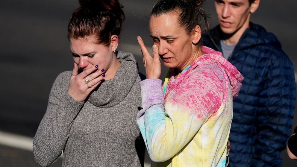 A couple cries at a makeshift display of bouquets of flowers on a corner near the site of a mass shooting over the weekend at a gay bar, Monday, Nov. 21, 2022, in Colorado Springs, Colo. (AP Photo/Jack Dempsey)