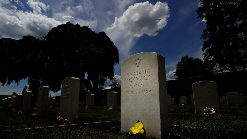 A flower sits at the base of headstone at the cemetery of the U.S. Army's Carlisle Barracks, Friday, June 10, 2022, in Carlisle, Pa. The Army is continuing a multi-phase project to disinter the remains of indigenous children who died more than a cent