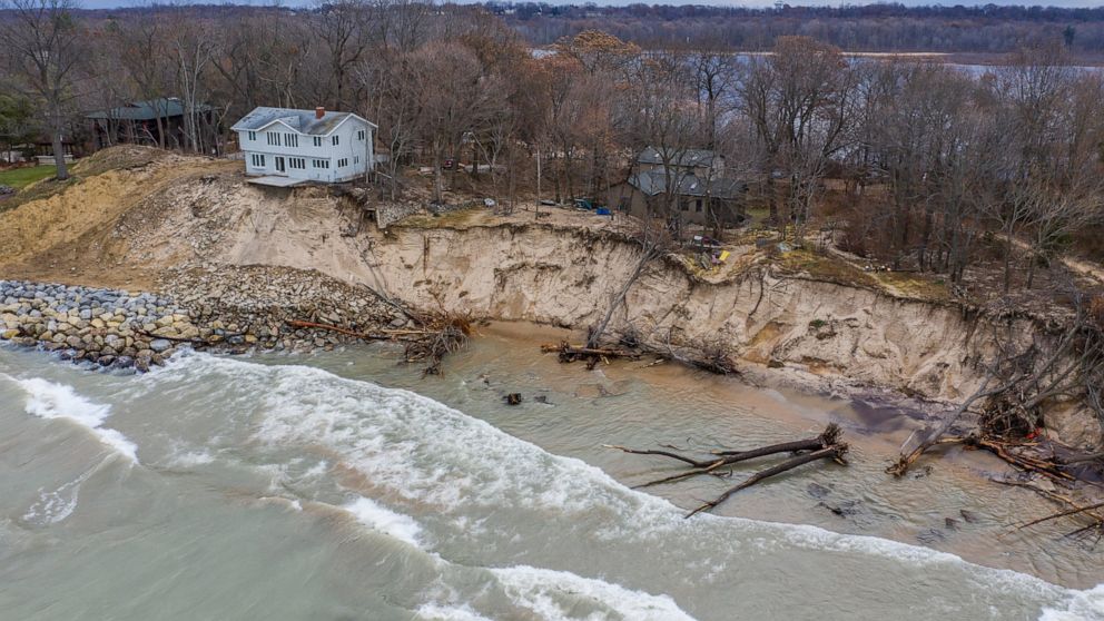 FILE - In this Dec. 4, 2019 file photo, erosion reaches a house along Lake Michigan's southwestern shoreline in Stevensville, Mich. Shoreline cities and towns in the Great Lakes region will be spending heavily in coming years to fix public infrastruc
