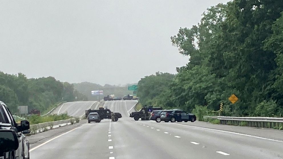 This photo provided by Massachusetts State Police shows police blocking off a section of Interstate 95 near Wakefield, Mass., on Saturday, July 3, 2021. Police say a group of heavily-armed men refuse to comply with law enforcement officers following 