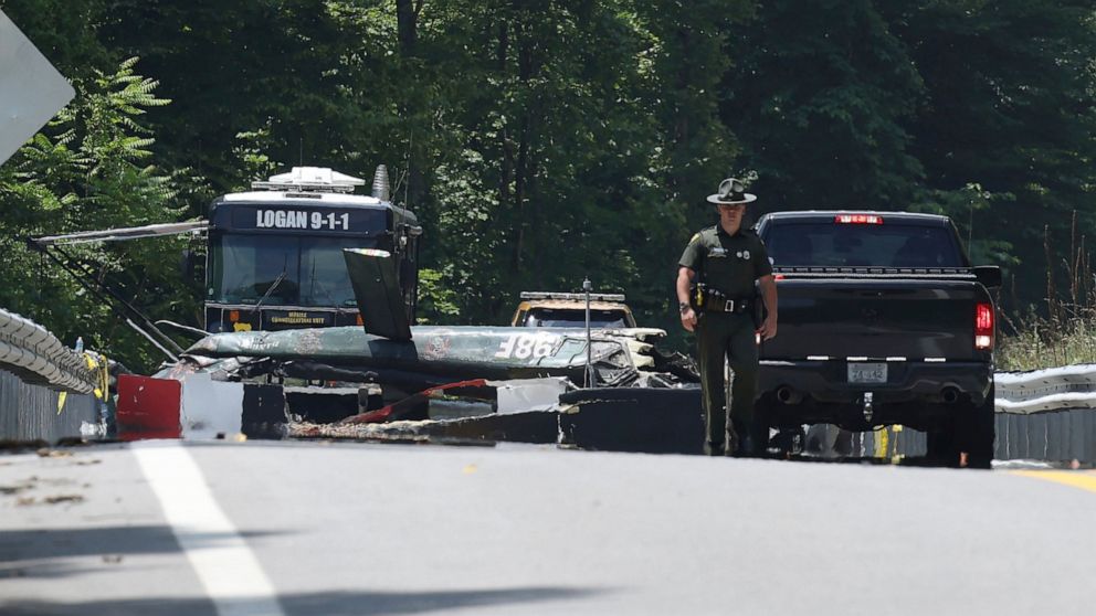Emergency personnel look over the sight of a helicopter that crashed in Blair, W.Va., on Thursday, June, 23, 2022. A Vietnam-era helicopter was used for tourism flights and crashed along Route 17 in Logan County about 5 p.m. Wednesday. County emergen