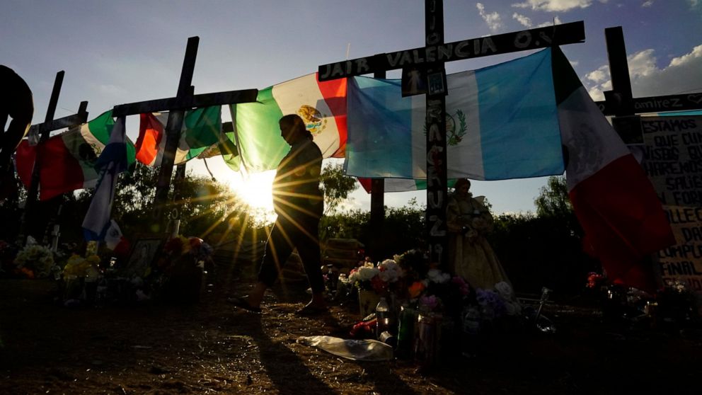 FILE - Mourners visit a make-shift memorial to honor the victims and survivors of a recent human smuggling tragedy on July 6, 2022, in San Antonio. Two men were indicted Wednesday, July 20 in the case of a hot, airless tractor-trailer rig found with 