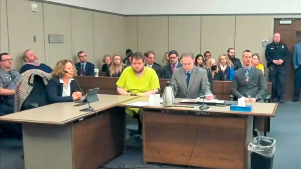 In this image taken from El Paso County District Court video, Anderson Lee Aldrich, 22, center, sits during a court appearance in Colorado Springs, Colo., Tuesday, Dec. Nov. 6, 2022. Aldrich, the suspect accused of entering a Colorado gay nightclub c