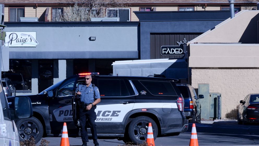 A police officer exits his car near a crime scene at a gay nightclub in Colorado Springs, Colo., Sunday, Nov. 20, 2022 where a shooting occurred late Saturday night. (AP Photo/Geneva Heffernan)