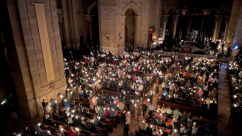 Hundreds of people light candles at the beginning of the Easter Vigil Mass at the Cathedral of St. Paul in St. Paul, Minn., on Saturday, April 16, 2022. For many U.S. Christians, this weekend marks the first time since 2019 that they will gather in p