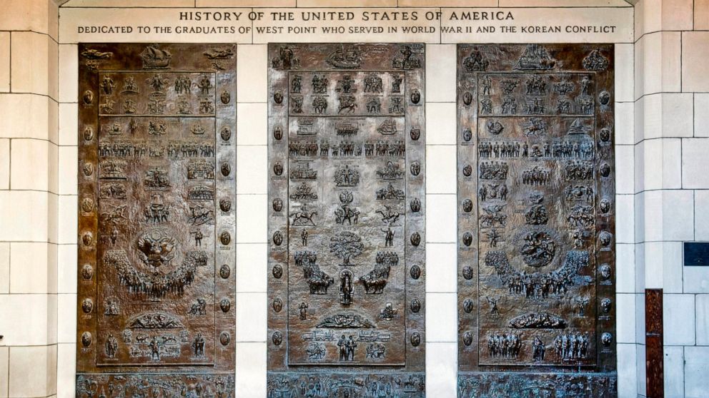 This photo provided by the U.S. Military Academy at West Point, in New York, shows the three bronze panels at one of the entrances to Bartlett Hall, at West Point, that depicts the history of the United States. A commission created by Congress is rec