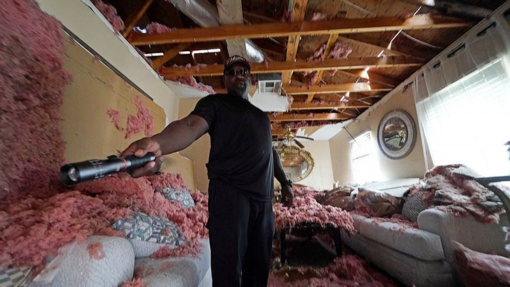 FILE - In this Sept. 7, 2021 file photo, Michael Lathers shows the insulation and collapsed ceiling in his flooded home, in the aftermath of Hurricane Ida in LaPlace, La. Destruction caused by Hurricane Ida has people in south Louisiana debating whet