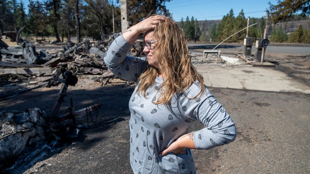 Hollie Jordan surveys her father's service station that was destroyed by a wildfire on Tuesday, Sept. 8, 2020, in Malden, Wash. "This was filled with work and life and memories and it's all gone," said Jordan. (AP Photo/Jed Conklin)