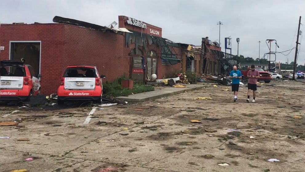 A pair of men walk though the parking lot of a strip mall that was destroyed by a deadly tornado that tore through the northern Louisiana city of Ruston early Thursday, April 25, 2019. (Jonathan Elmer/The Tech Talk via AP)