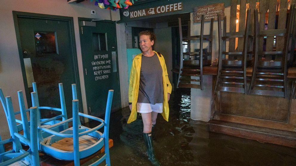 Aimee Cutter the owner of Beach House restaurant walks through water surge from Lake Pontchartrain on Lakeshore Drive in Mandeville, La., ahead of Tropical Storm Barry, Saturday, July 13, 2019. Barry is expected to reach hurricane strength by the tim