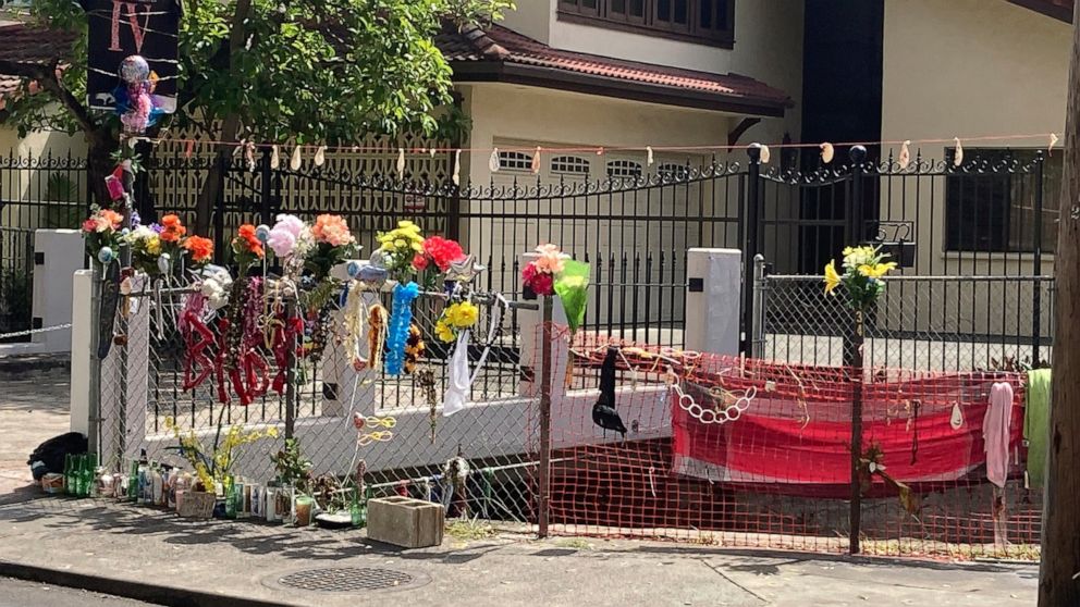In this Wednesday, April 28, 2021, photo floral bouquets, deflated balloons, candles and other items decorate a street memorial by the Kalakaua Canal where Honolulu Police shot and killed 16-year-old Iremamber Sykap, whose nickname was Baby, during a