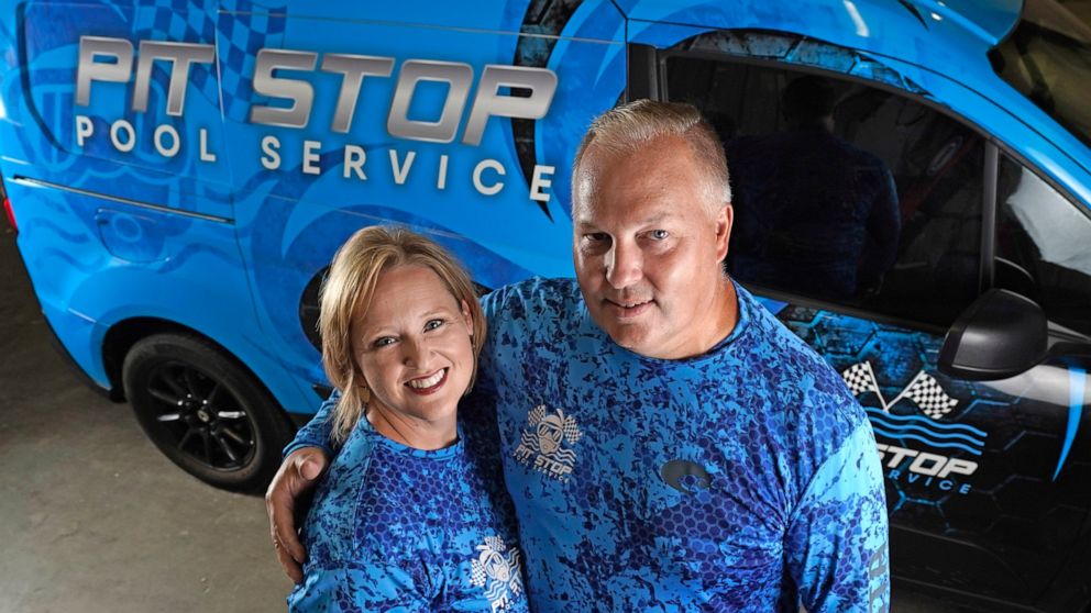 Amy and Cody Morgan pose in their new warehouse, Friday, Sept. 4, 2020, in Cypress, Texas. The couple, who lost their jobs as corporate executives during the coronavirus pandemic, decided to start a pool servicing company, Pit Stop Pools. (AP Photo/D