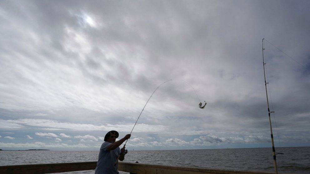 FILE - In this Sept. 5, 2018 file photo, Tim Hitchens, of Gulfprort, Miss., pulls in a fish while fishing from a pier in the Gulf of Mexico, the morning after Tropical Storm Gordon made landfall nearby, in Biloxi, Miss. The rules that govern recreati