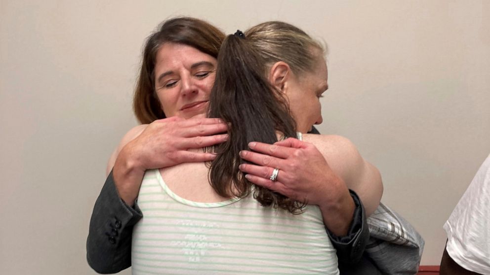 Dawn McIntosh hugs O'Fallon, Missouri, Detective Jodi Weber on Monday, Sept. 19, 2022, after a news conference announcing that a man has been charged for killing four women in the St. Louis area in 1990 in Clayton, Mo. McIntosh's mother, Donna Reitey