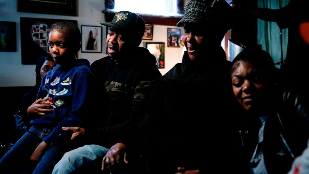 Wayne Jones, center left, accompanied by his aunt JoAnn Daniels, center right, son Donell Jones, left, and daughter Kayla Jones, speaks during an interview with The Associated Press, Monday, May 16, 2022, about his mother, Celestine Chaney, who was k