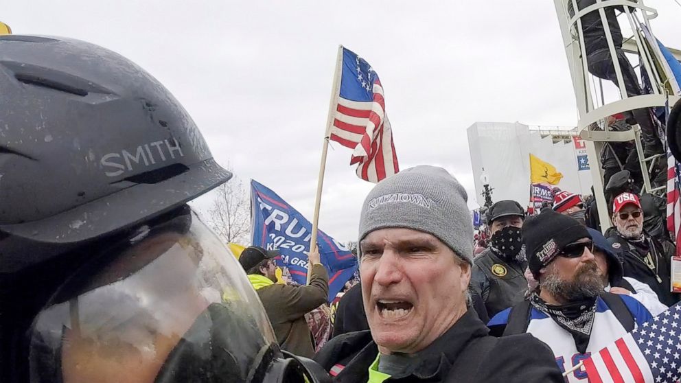FILE - In this image from video, Alan William Byerly, center, attacks an Associated Press photographer during a riot at the U.S. Capitol in Washington, Jan. 6, 2021. On Sunday, Oct. 9, 2022, federal prosecutors recommended a prison sentence of nearly