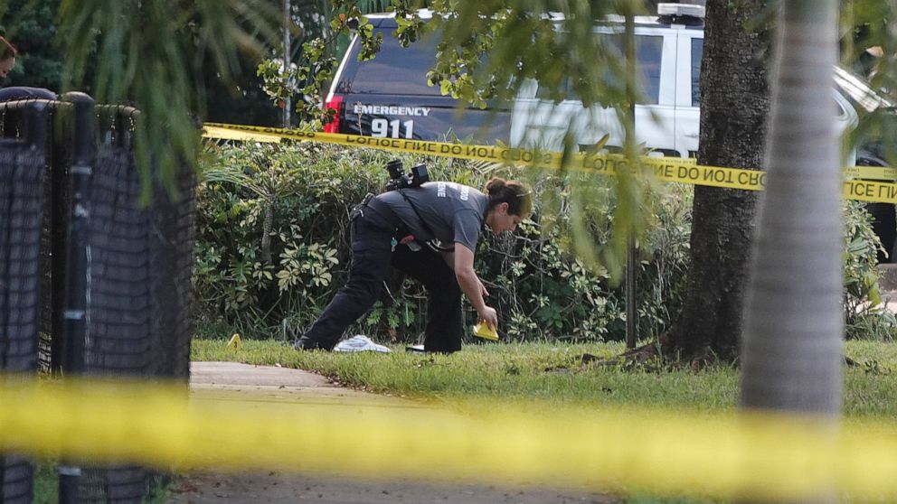 A Hollywood Police crime scene investigator places markers at the scene where officer Yandy Chirino was killed in Hollywood, Fla., Monday Oct. 18, 2021. The officer was killed during a late-night altercation with a teenaged suspect and died at the ho