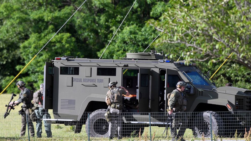 Tactical police work near where a man opened fire at a business, killing three people before the suspect and a state trooper were wounded in a shootout, according to authorities, in Smithsburg, Md., Thursday, June 9, 2022. The Washington County (Md.)