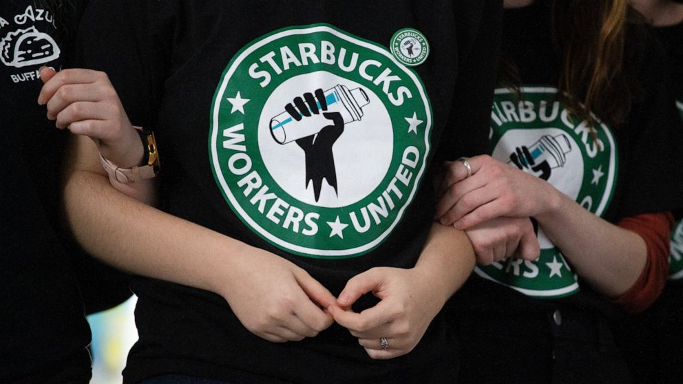 FILE - Starbucks employees and supporters react as votes are read during a union-election watch party on Thursday, Dec. 9, 2021, in Buffalo, N.Y. It’s become a common sight: jubilant Starbucks workers celebrating after successful votes to unionize at