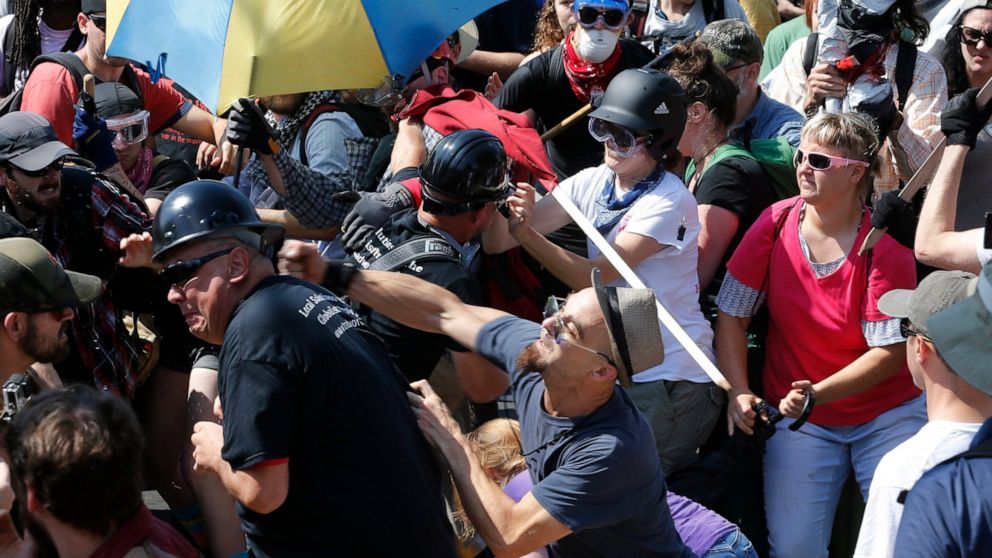 FILE - In this Aug. 12, 2017 file photo, white nationalist demonstrators clash with counter demonstrators at the entrance to Lee Park in Charlottesville, Va. Two more members of a white supremacist group have pleaded guilty to federal rioting charges