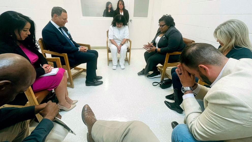 In this April 6, 2022 photo provided by Texas state Rep. Jeff Leach, Texas death row inmate Melissa Lucio, dressed in white, leads a group of seven Texas lawmakers in prayer in a room at the Mountain View Unit in Gatesville, Texas. The lawmakers visi