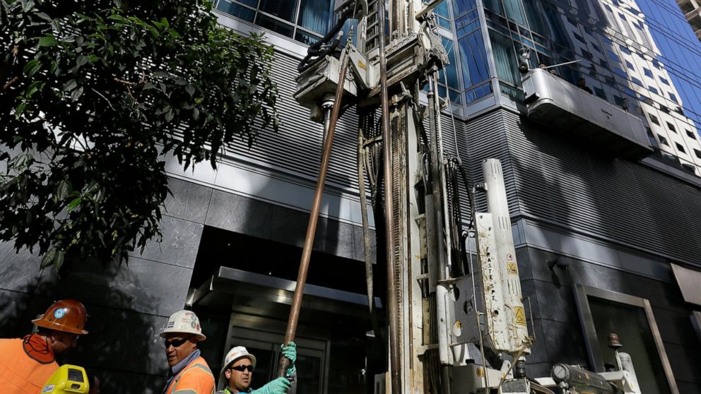 FILE - In this Sept. 26, 2016, file photo, independent soil engineers install data collection devices and obtain soil samples outside the Millennium Tower in San Francisco. A $100 million fix to stop the San Francisco luxury high-rise from sinking an