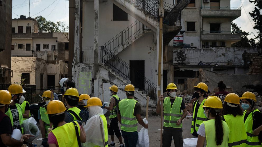 Volunteers from the American University of Beirut gather as they prepare to help remove debris in a neighborhood near the site of last week's explosion that hit the seaport of Beirut, Lebanon, Thursday, Aug. 13, 2020. (AP Photo/Felipe Dana)