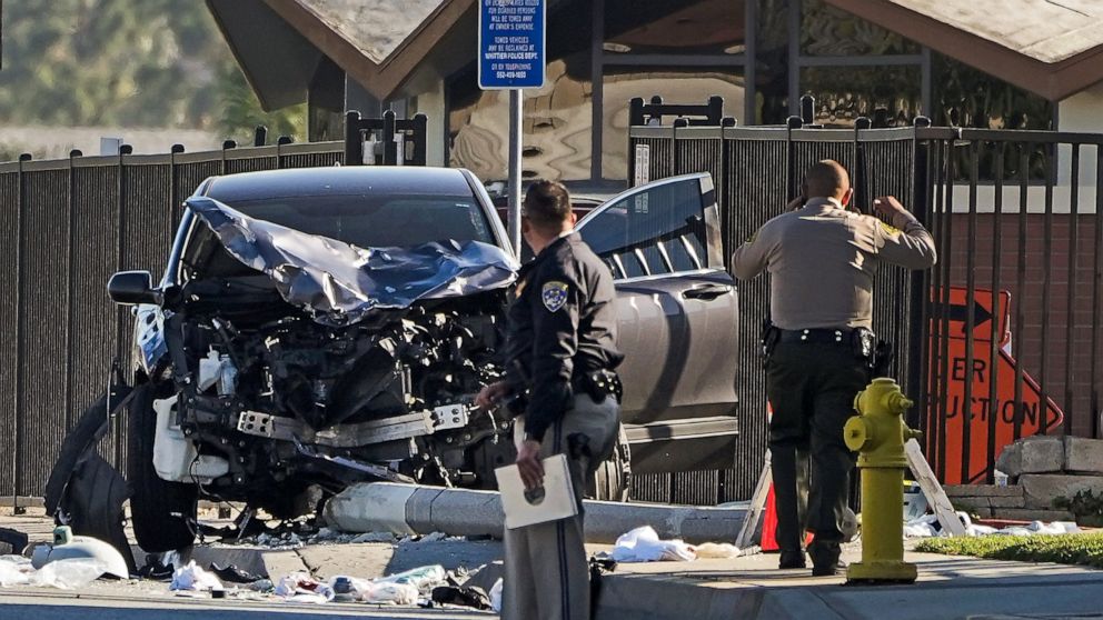FILE - Two investigators stand next to a mangled SUV that struck Los Angeles County sheriff's recruits in Whittier, Calif., Wednesday, Nov. 16, 2022. One of the Los Angeles County law enforcement recruits struck by the SUV during a training run last 
