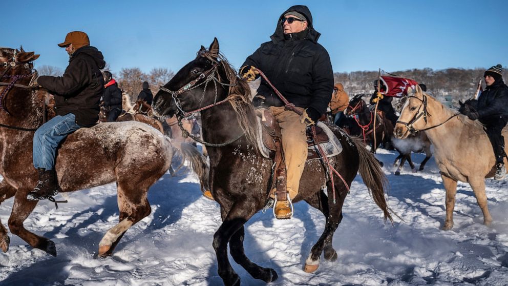 Riders on their last leg of the journey from South Dakota take off from Land of Memories to Reconciliation Park in Mankato, Minn., Monday, Dec. 26, 2022. (Jerry Holt/Star Tribune via AP)