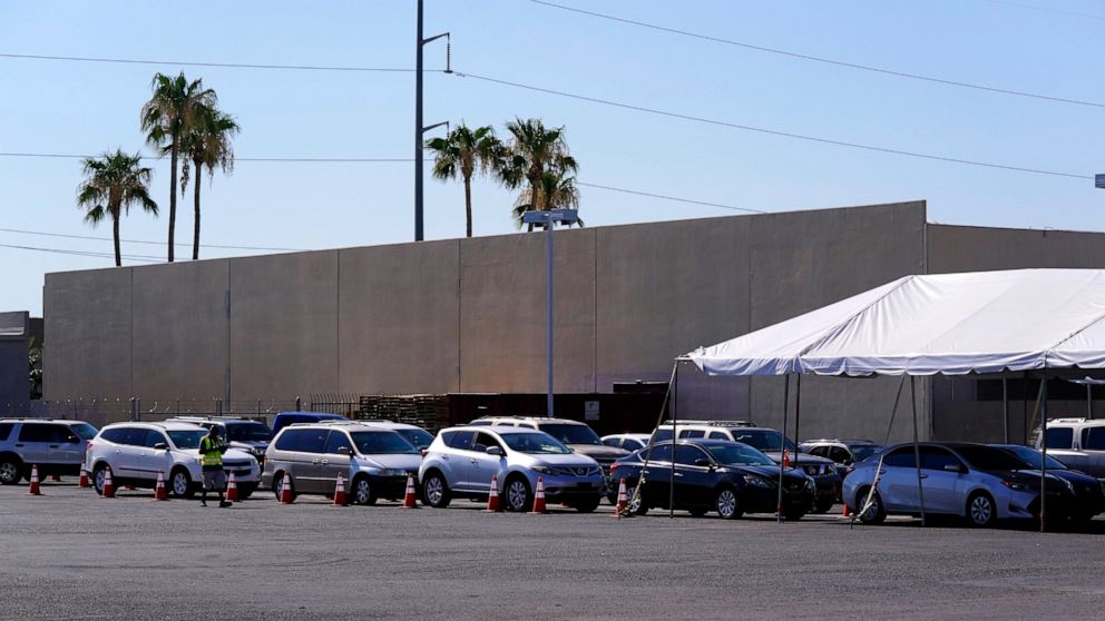 Dozens of vehicles line up to get food boxes at the St. Mary's Food Bank Wednesday, June 29, 2022, in Phoenix. Long lines are back at outside food banks around the U.S. as working Americans overwhelmed by inflation increasingly seek handouts to feed 