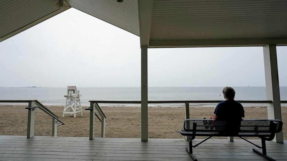 Dr. Robert Long watches the rain fall on the Long Island sound on Penfield beach as Tropical Storm Henri approaches, Sunday, Aug. 22, 2021, in Fairfield, Conn. (AP Photo/Mary Altaffer)