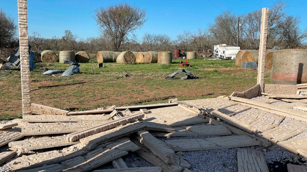Debris lines the roads as crews and homeowners work to repair properties damaged by severe weather in Elgin, Texas, Tuesday, March 22, 2022. Officials say multiple tornadoes ripped through parts of Texas and Oklahoma on Monday. (AP Photo/Acacia Coronado)