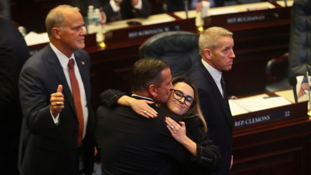 At center, Rep. Bob Rommel, R-Naples kisses Rep. Josie Tomkow, R-Polk City after his SB 2-A Property Insurance bill he co-sponsored passed 84-33 Wednesday, Dec. 14, 2022 in the House of Representatives in Tallahassee, Fla. At left is Rep. Bobby Payne