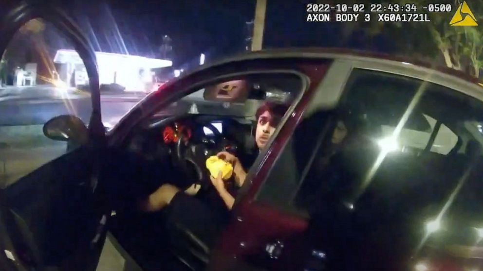 FILE - In this image taken from Oct. 2, 2022, police body camera video and released by the San Antonio Police Department, Erik Cantu looks toward San Antonio Police Officer James Brennand while holding a hamburger in a fast food restaurant parking lo