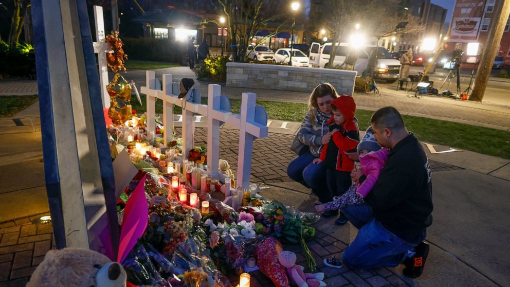 FILE - A family visits a memorial at Veteran's Park for the victims of Sunday, Nov. 21, 2021's deadly Christmas parade crash in Waukesha, Wis. on Nov. 23, 2021. A Wisconsin judge is poised to decide Friday whether Darrell Brooks, Jr.,a Milwaukee man 