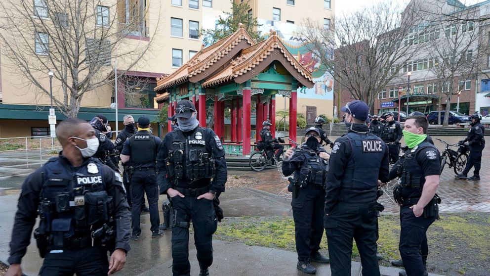 Seattle Police officers disperse after taking part in a public roll call at Hing Hay Park in the heart of Seattle's Chinatown-International District Thursday, March 18, 2021, at the start of their shift as part of a community response unit. Due to re