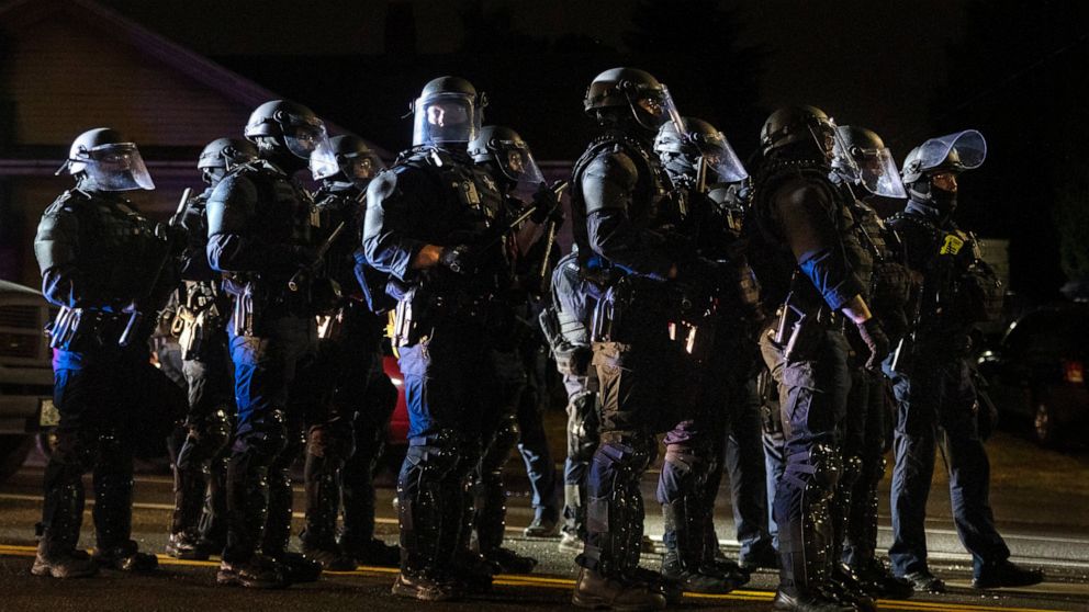 Portland police take control of the streets after making arrests on the scene of the nightly protests at a Portland police precinct on Sunday, Aug. 30, 2020 in Portland, Ore. Oregon State Police will return to Portland to help local authorities after