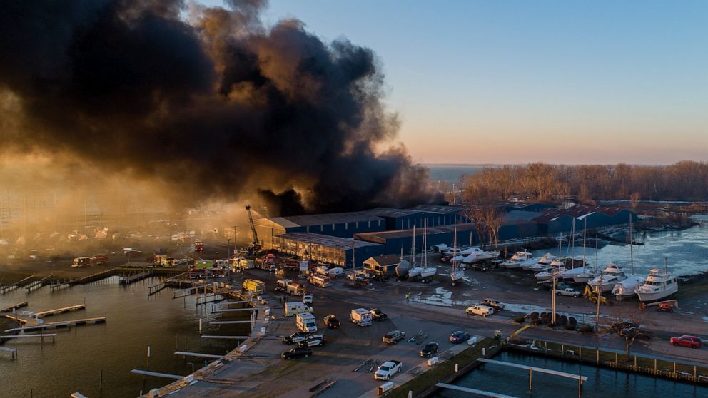 Firefighters battle a large blaze at Toledo Beach Marina in LaSalle, Mich., Friday, Dec. 4, 2020. The number of boats at Toledo Beach Marina could be in the hundreds, said Monroe County emergency manager Mark Hammond. No injuries were reported. (Andy
