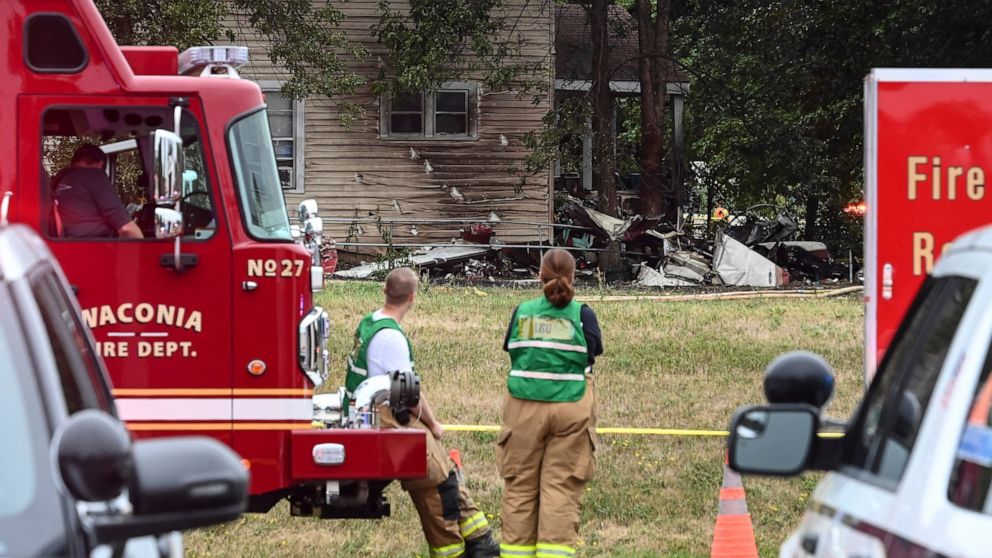 Firefighters look on at the scene of a plane crash, Sunday, Aug. 8, 2021 in Victoria, Minn. Three people died when a single-engine plane crashed into a vacant lot and burst into flames in a small southeastern Minnesota city, a National Transportation