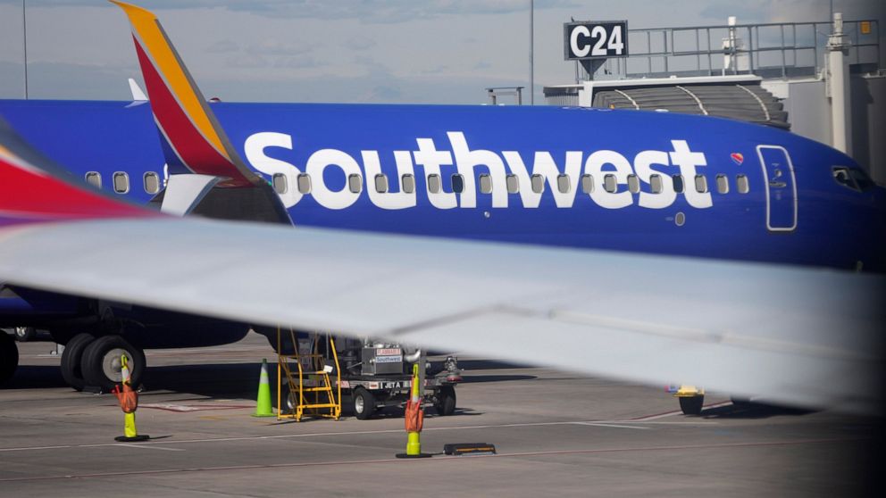 FILE - A Southwest Airlines jetliner sits at a gate on the C concourse of Denver International Airport on Wednesday, Oct. 6, 2021, in Denver. A Southwest Airlines pilot is suing the company, her union and a former colleague who pleaded guilty last ye