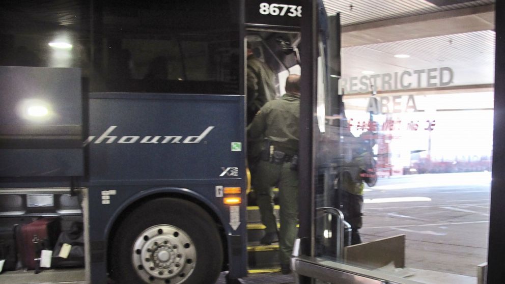 FILE - In this Thursday, Feb. 13, 2020 file photo, agents for Customs and Border Protection board a Greyhound bus headed for Portland, Ore., at the Spokane Intermodal Center, a terminal for buses and Amtrak, in Spokane, Wash. Greyhound Lines Inc. wil