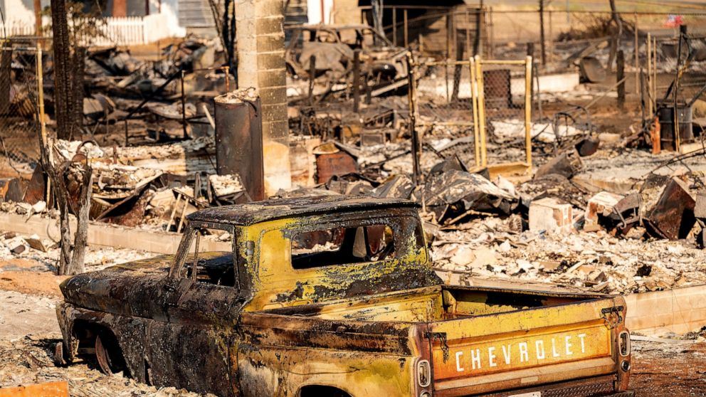 FILE - A scorched pickup truck sits in front of a Wakefield Avenue home destroyed by the Mill Fire on Saturday, Sept. 3, 2022, in Weed, Calif. A wood products company said Wednesday, Sept. 7, 2022 that it is investigating whether a fire that killed t