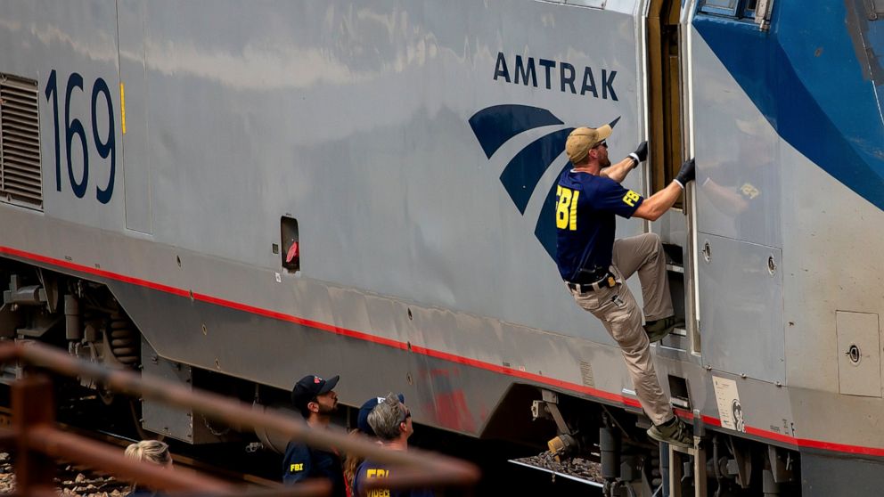 A Federal Bureau of Investigation agent boards an Amtrak train after a shooting aboard the train in downtown Tucson, Ariz., on Monday, Oct. 4, 2021. (Rebecca Sasnett/Arizona Daily Star via AP)