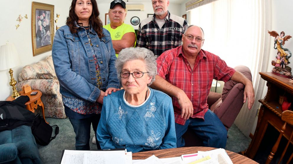 In this undated photo, Edna Schmeets, 90, poses for a picture with her children, from left, Lisa Appelt, and Ron, Tim and Jeff Schmeets, at her home in Harvey, N.D. On the table are some of the copious documents the family has collected detailing Edn