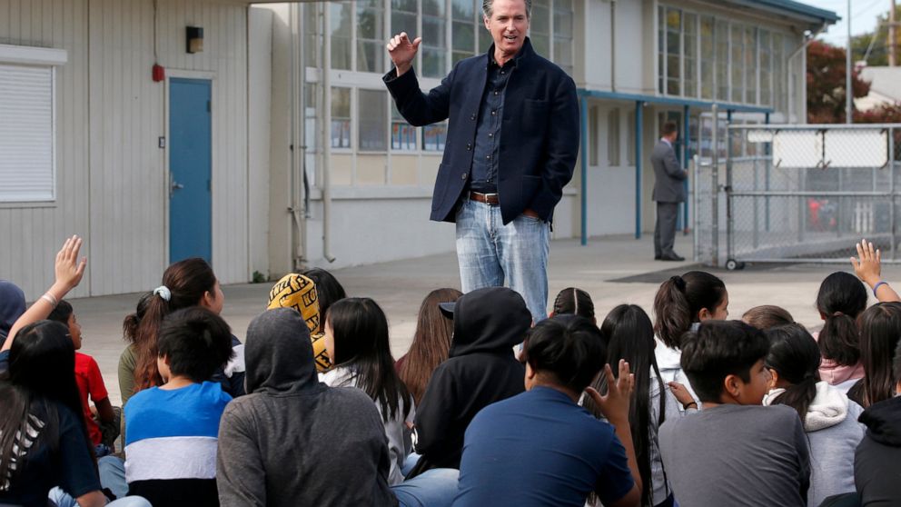 FILE - In this Monday Oct. 7, 2019 file photo, California Gov. Gavin Newsom talking to students during his visit to the Ethel I. Baker Elementary School in Sacramento, Calif. Newsom wants a three-year suspension on physical fitness tests while the st