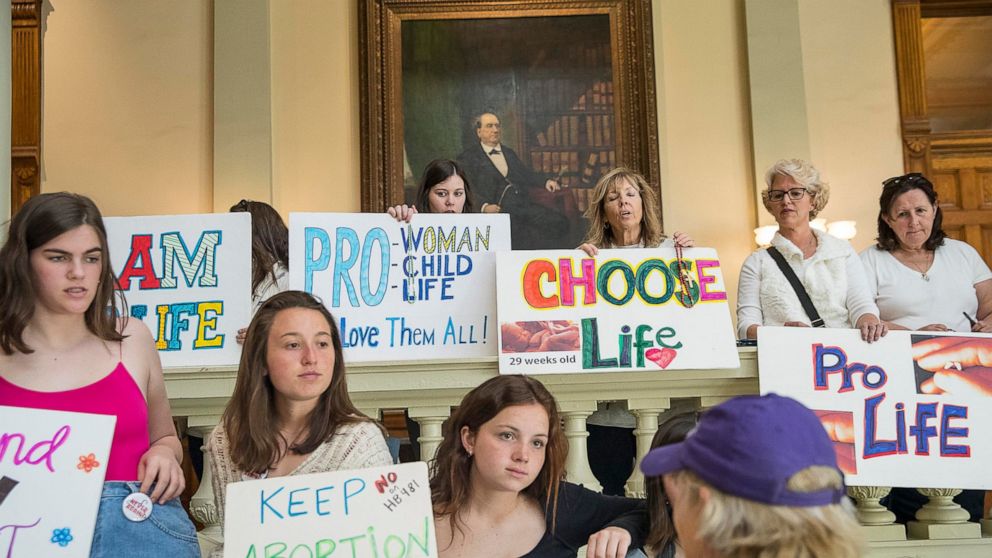 File-This March 22, 2019, file photo shows, pro-abortion rights and anti-abortion demonstrators displaying their signs in the lobby of the Georgia State Capitol building during the 35th legislative day at the Georgia State Capitol building in downtow