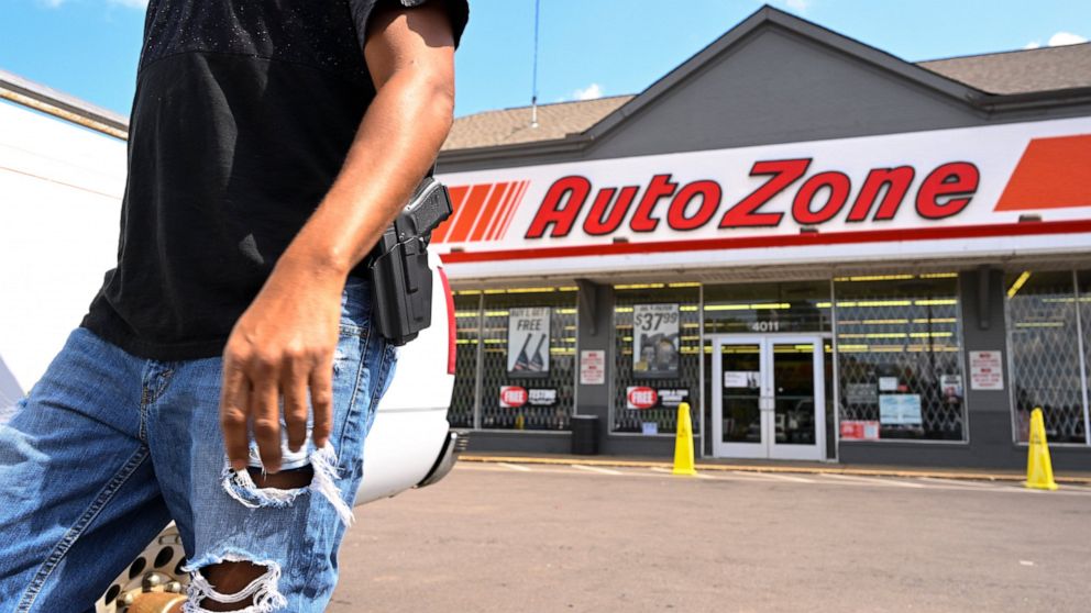 FILE - A man carrying a firearm on his hip for protection leaves an Auto Zone store, Thursday, Sept. 8, 2022, in Memphis, Tenn. On Thursday, Sept. 13, 2022, police revised the number of people killed in a man's shooting rampage from four to three aft